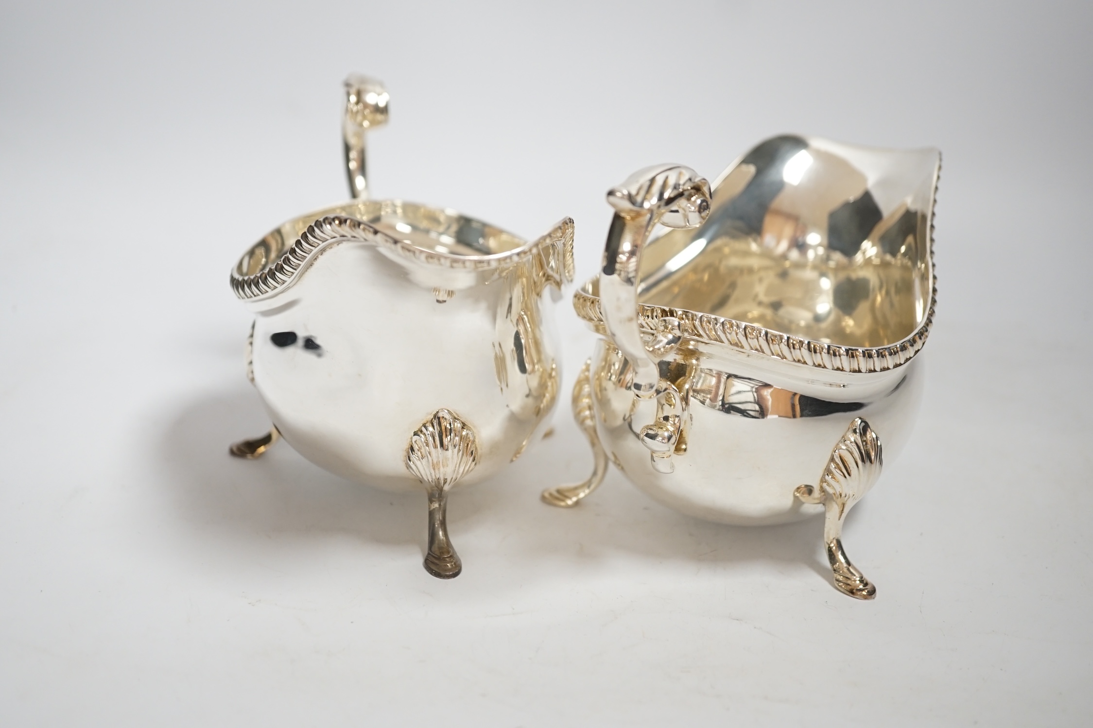 A pair of Elizabeth II silver sauceboats, with flying scroll handles, by Garrard & Co, London, 1961, length 17.9cm, 20oz.